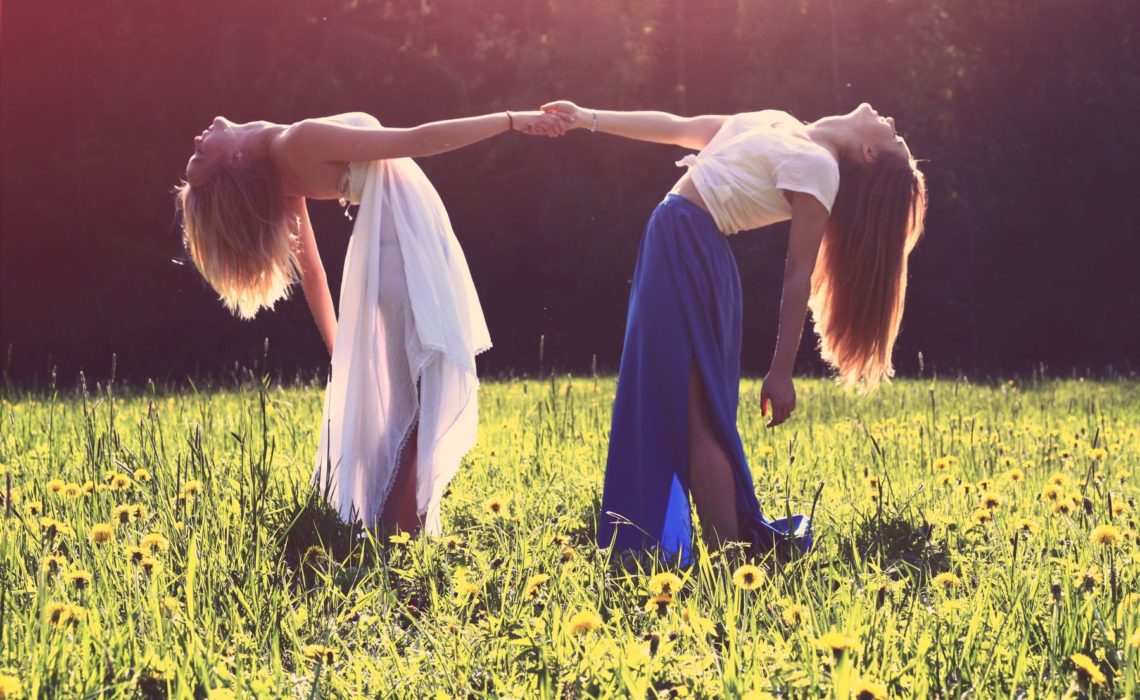 Frauen tanzen freudig im Gras nach einem Women's Circle
